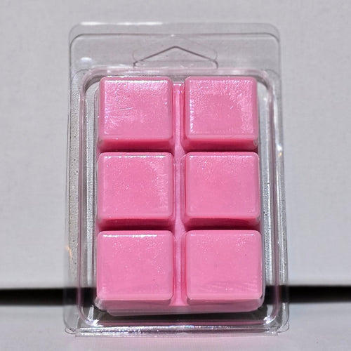 Pink wax melts in a clear plastic packaging on a light gray background